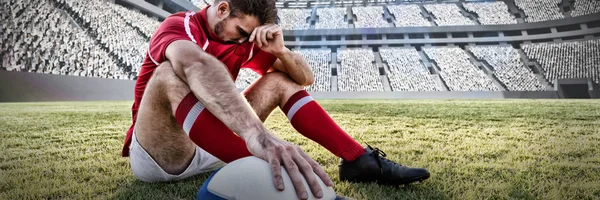 Caucasian male rugby player on field against rugby stadium