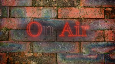 Kırmızı tuğla duvar arka planda kırmızı titreşen neon harflerle görünen On Air kelimelerinanimasyonu