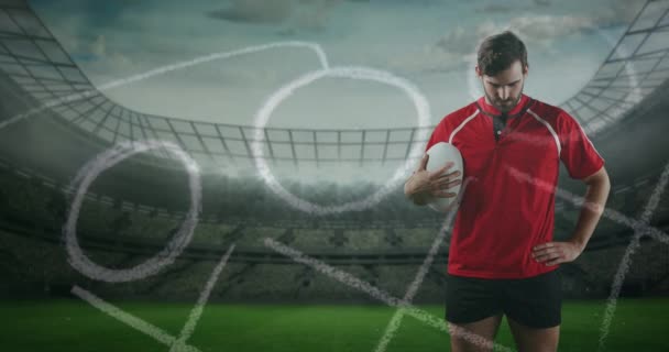 一个白人男性橄榄球运动员站立的动画 手里拿着一个球 看着相机与手绘的游戏计划在前台和体育场的背景4K — 图库视频影像