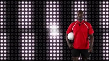 Bir top tutan ve arka planda beyaz ışıklar hareketli dijital ekran ile kameraya bakan bir Afrikalı-Amerikalı erkek rugby oyuncusu Animasyon