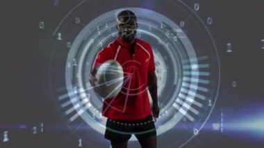 Bir Afro-Amerikan erkek rugby oyuncusu bir top ile oynarken ve ikili kodlama ile kameraya bakarak Animasyon, daire iplik ve gri bir arka plan üzerinde görünen veri