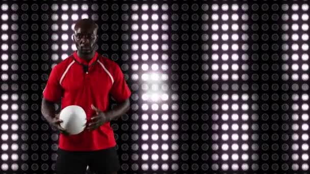 一个非裔美国男子橄榄球运动员拿着一个球 看着相机与图像显示移动白灯的背景动画 — 图库视频影像