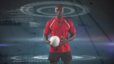 Bir Afro-Amerikan erkek rugby oyuncusu bir top ile oynarken ve daireler dönen ve gri bir arka plan üzerinde görünen veri ile kameraya bakarak Animasyon