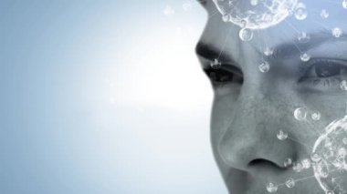 Veri ve bağlantı ağıyla dönen iki kürenin animasyonu. Mavi arka planda genç bir beyaz adamın yüzünün yan görüntüsü.
