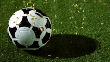 Altın konfeti düşen bir futbol sahası na yerleştirilen bir futbol yakın çekim animasyonu