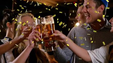 Altın konfeti ön planda düşerken, kutlama ve içki yapan çok ırklı bir grup genç erkek ve kadın arkadaşın animasyonu