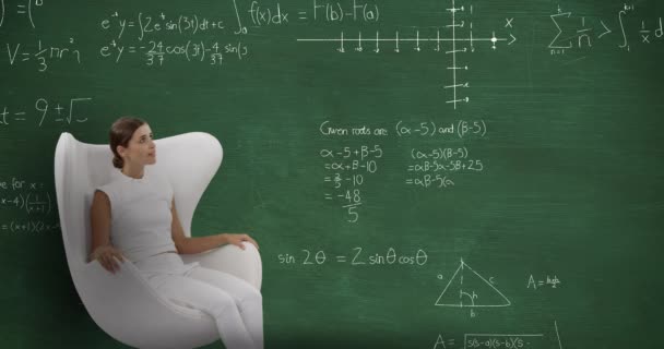 笑顔の白人女性のアニメーション顎の上に手を白い服を着て彼女の4Kの後ろの黒板にチョークで書かれた数学計算を動かすと白い椅子に座って — ストック動画