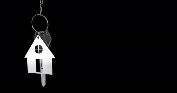 黒い背景4Kに掛かる銀の家の鍵と家の形のキーフォブのアニメーション — ストック動画