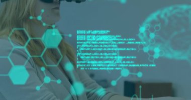 Bilimsel verilerin ön planda yüzerken görüntüsü. Kafkasyalı genç bir kadın, VR kulaklık takıyor ve arka planda bilgisayar kullanıyor.