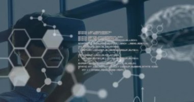 Bilimsel verilerin ön planda beyaz olarak yüzmesi VR kulaklık takan, etkileşimli bir ekrana dokunan ve arka planda 4K 'de gülümseyen genç beyaz bir adamın yakın çekimi.