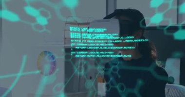 Bilimsel verilerin ön planda, VR kulaklık takan, gülümseyen ve arka planda etrafa bakınan genç beyaz bir kadınla birlikte yüzen yeşil renkli animasyonu.