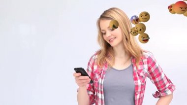 Sağdan sola uçan emoji simgelerinin animasyonu. Akıllı telefon kullanan ve arka planda bir ekran gösteren beyaz bir kadın.