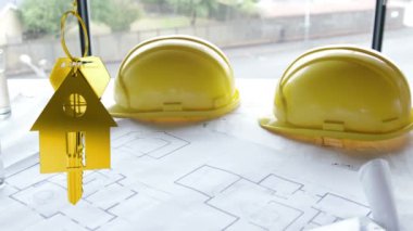 Animation of golden house keys and house shaped key fob hanging over architectural drawing and two yellow hard hats in the background
