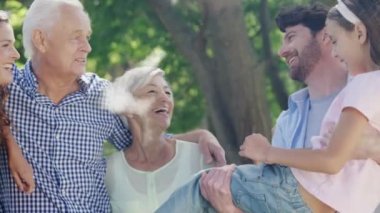 Arka planda kucaklaşan üç nesildir beyaz bir ailenin yüzdüğü buluttan yapılmış bir evin animasyonu