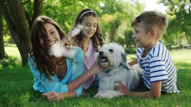 由白种人家庭和他们的狗躺在草地上的云彩构成的房子形动画 — 图库视频影像