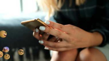 Arka planda akıllı telefon kullanan bir kadının orta bölümüyle soldan sağa uçan emoji simgelerinin animasyonu