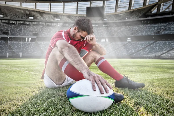 Caucasian male rugby player on field against rugby stadium on a sunny day