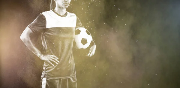 Tough female soccer player against splashing of color powder