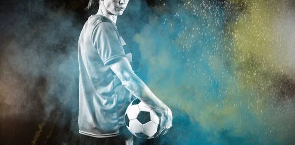 Tough female soccer player against splashing of color powder