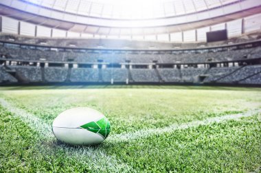 Rugby ball on a grass in the stadium against rugby goal post on a sunny day in the stadium clipart