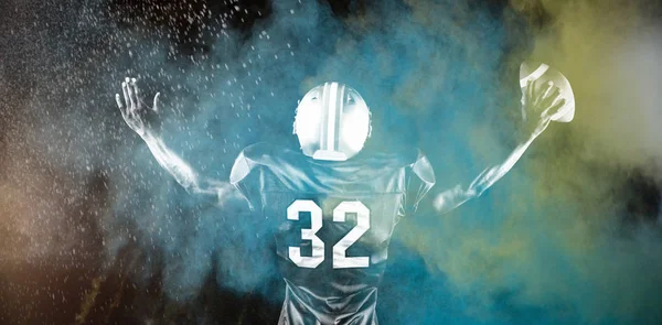 强大的橄榄球运动员反对飞溅的彩色粉末 — 图库照片