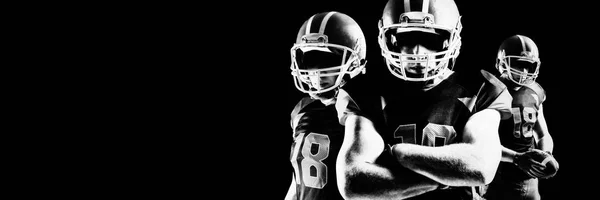 戴着钢盔站在橄榄球旁边的年轻美国足球运动员 — 图库照片