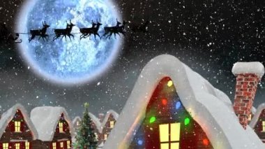 Geceleyin Noel Baba 'nın kızakla çektiği kış manzarası ren geyikleri, kar yağışı, ay ve evler tarafından çekiliyor.
