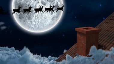 Geceleyin Noel Baba 'nın kızakla çektiği kış manzarası ren geyikleri, kar, ay ve ev tarafından çekiliyor.