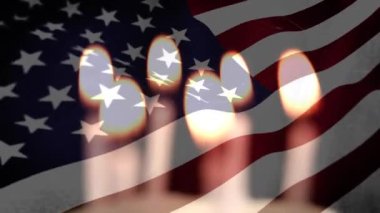 Arka planda dalgalanan Amerikan bayrağıyla yanan ve sönen mumların animasyonu