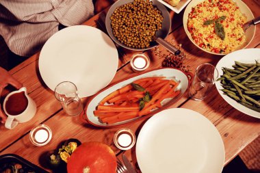 Evde Şükran yemek masasında sebze, tabak ve mumyüksek açı görünümü