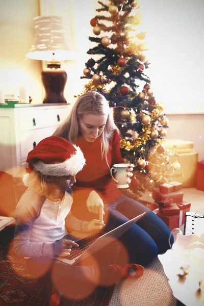 彼女の息子と一緒に女性に対する茶色のパケットの複合画像自宅でクリスマス時にラップトップを使用して — ストック写真