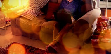 Yılbaşı zamanı evde dizüstü bilgisayar kullanan adama karşı kahverengi parkenin birleşik görüntüsü