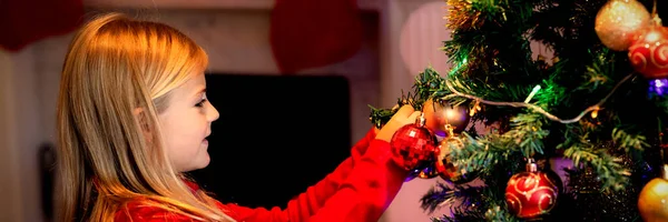 크리스마스 시간에 거실에서 크리스마스 트리를 장식하는 소녀의 — 스톡 사진