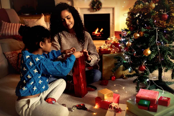 クリスマスの間 彼女の若い娘と一緒に床に座っている混合人種の女性の正面図 笑顔とラッピングプレゼント — ストック写真