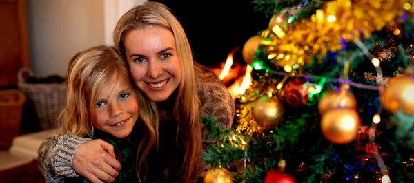 크리스마스 자신의 거실에 바닥에 그녀의 아들을 여성의 전면보기 카메라에 — 스톡 사진