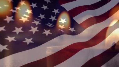 Arka planda dalgalanan Amerikan bayrağıyla yanan mumların canlandırılması