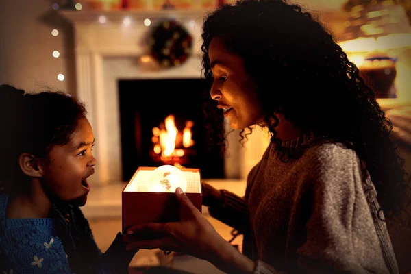 クリスマスに自分の居間で彼女の若い娘と混合レースの女性のサイドビュークローズアップ 笑顔とプレゼントを与える — ストック写真