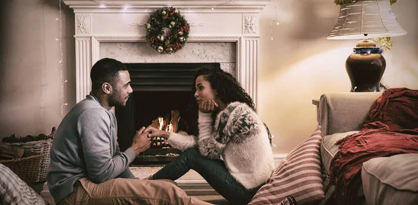 クリスマスの居間で混血のカップルのサイドビュー 手をつないでお互いに直面して — ストック写真