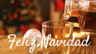 Feliz Navidad sözcüğünün canlandırması beyazla yazıldı ve arkaplanda Noel ağacı ile birlikte içki döküldü.