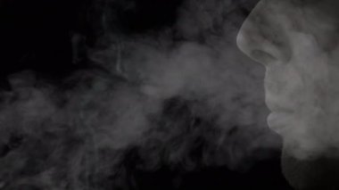 Kafkasyalı bir adamın yüzüne yakın bir şekilde sigara dumanı püskürten bir yan görüntünün canlandırması.