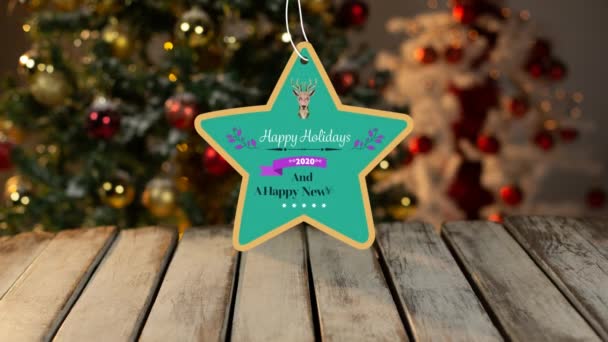 快乐假期和2020年新年快乐 字样的动画 写在一个星形绿色的标签上 后面装饰着驯鹿 背景是一棵圣诞树 — 图库视频影像
