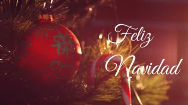 Feliz Navidad 'ın Noel ağacının üzerine beyaz ve arka planda kırmızı mücevherlerle yazdığı animasyon.
