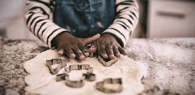 Noel'de bir mutfakta çocuğun ön görünümü orta bölümü, kurabiye yapma ve şekiller kesme