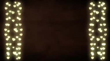 Gri arka planda, kalp şeklinde parlak iplerle parıldayan bir Noel süslemesinin animasyonu