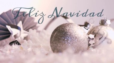 Yeşille yazılmış Feliz Navidad kelimelerinin animasyonu ve arka planda Noel süslemeleri