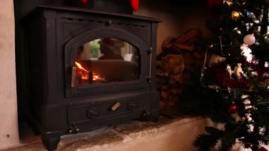 Frohe Weihnachten kelimelerinin canlandırması şöminenin üzerine beyaz yazıldı ve arka planda Noel süslemeleri.