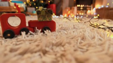 Noel zamanı oturma odasının üzerinde beyaz harflerle Frohe Weihnachten yazısının animasyonu. Arka planda Noel ağacı ve Noel çorapları var.