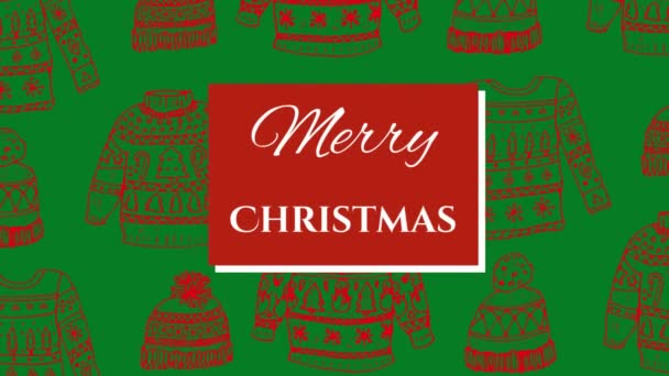 赤いジャンパーと緑の背景に帽子の上に赤い正方形に白い文字で書かれた単語メリークリスマスのアニメーション — ストック動画