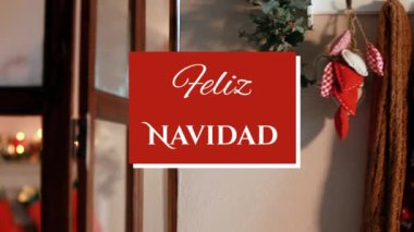Noel süsleri ve arka planda ökseotu olan kırmızı karenin üzerine beyaz harflerle yazılmış Feliz Navidad sözlerinin animasyonu