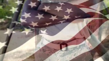 Kollarını bağlayan Afro-Amerikan askerinin üzerinde sallanan Amerikan bayrağı animasyonu. Amerika Birleşik Devletleri bayrağı ve tatil konsepti dijital kompozisyon